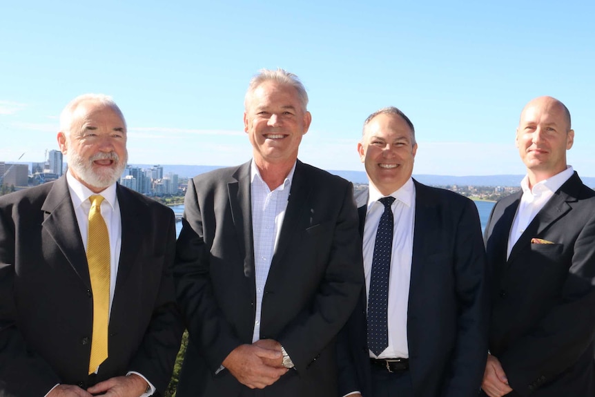 Four men with city in background