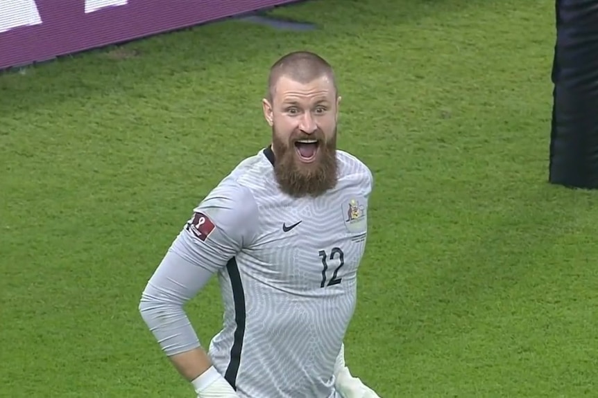 Andrew Redmayne poses with a huge smile after winning the penalty shoot out for the Socceroos in 2022