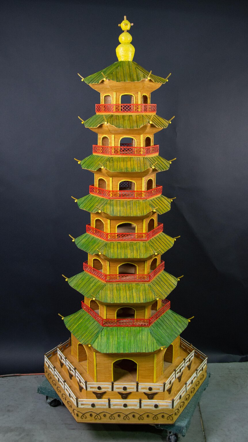 A model of a tall Chinese pagoda built made of matchsticks.