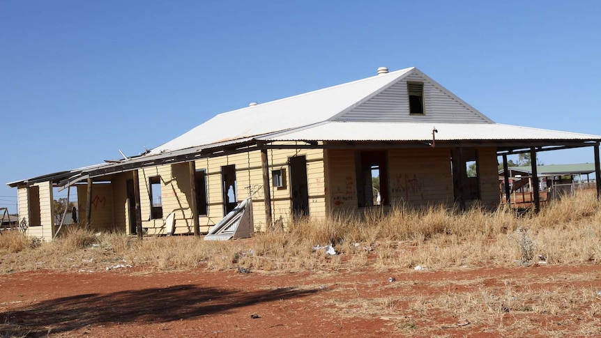 a dilapidated house in a dry outback location