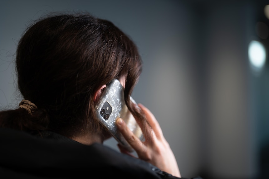 A close up from behind of a woman on the phone