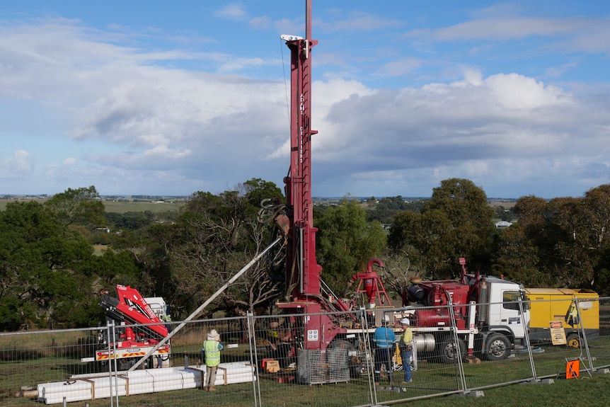 A large drilling rig at a lake.