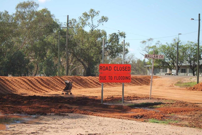 A road closed sign in front of a road