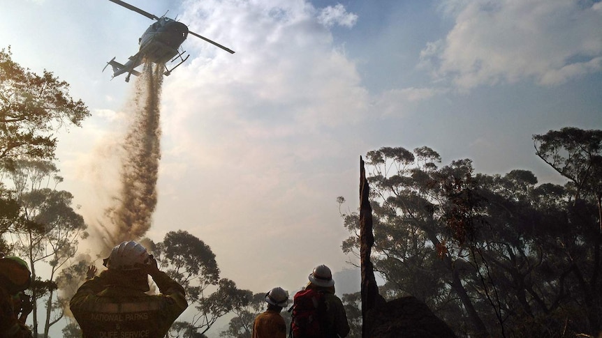 Remote area firefighting team call in a water-bombing helicopter