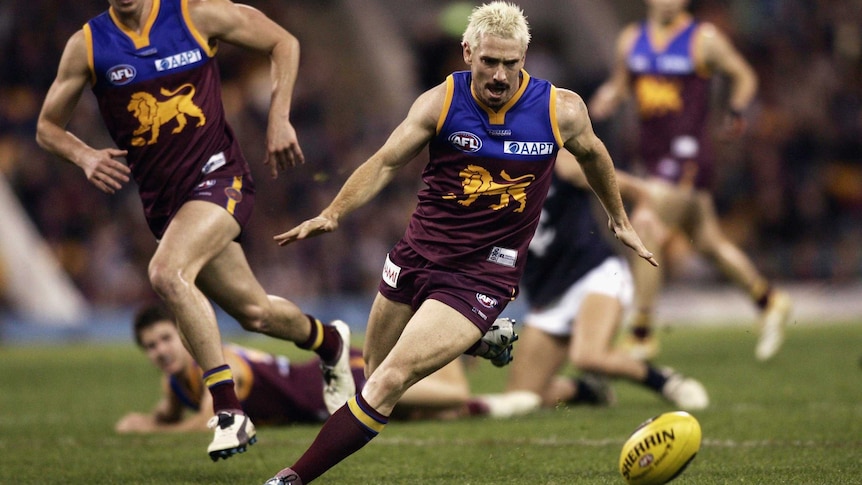 Jason Akermanis runs with the ball for the Brisbane Lions