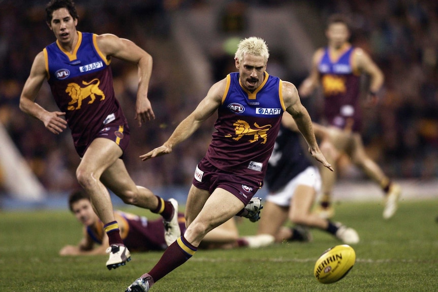 Jason Akermanis runs with the ball for the Brisbane Lions