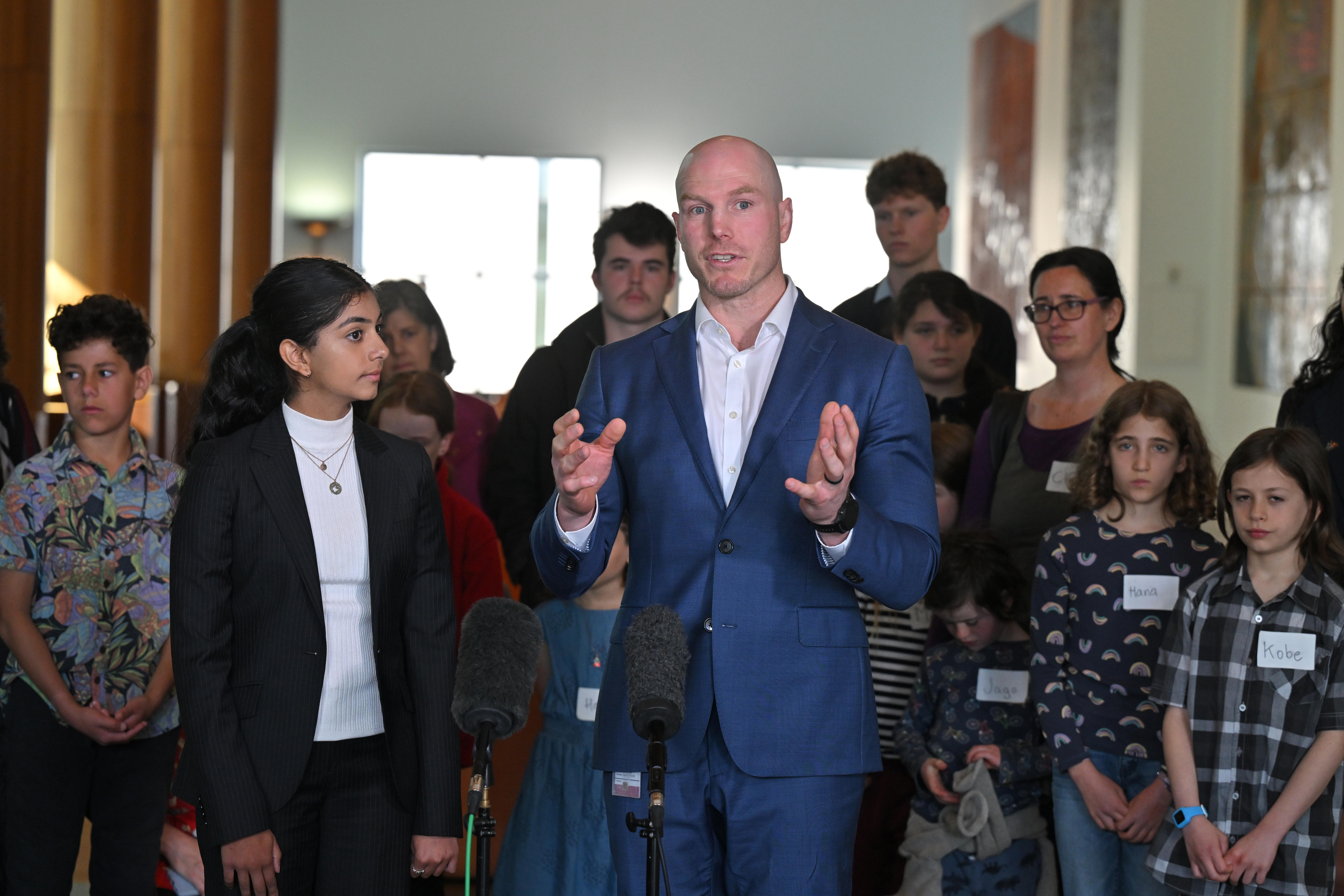 Anjali stands next to David Pocock surrounded by media