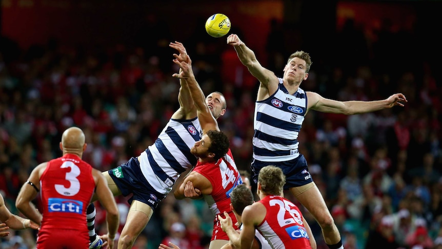 Geelong's Mark Blicavs (L) and Trent West leap highest over the Swans pack.