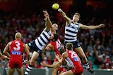 Geelong's Mark Blicavs (L) and Trent West leap highest over the Swans pack.