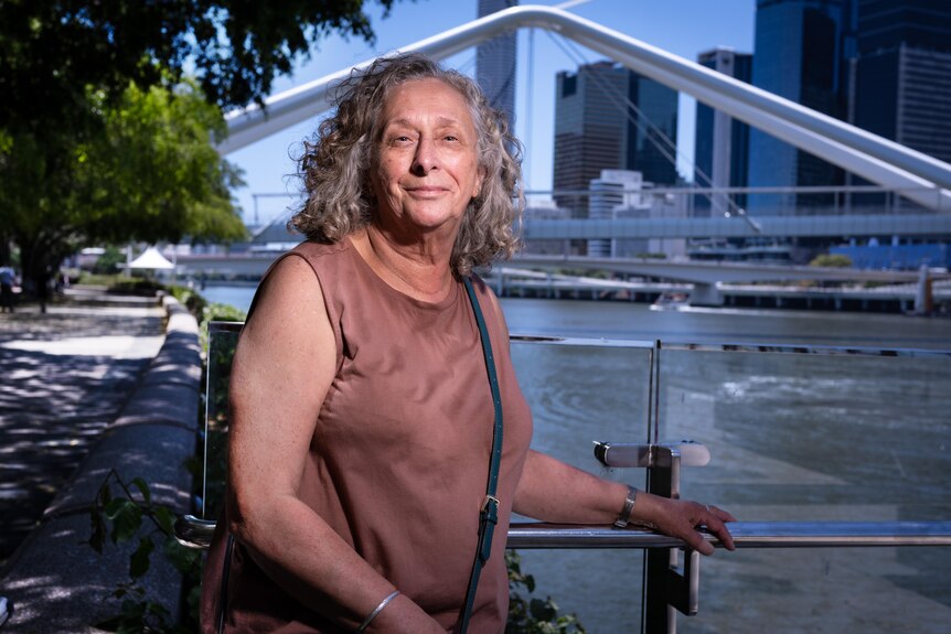 A woman next to a river cityscape