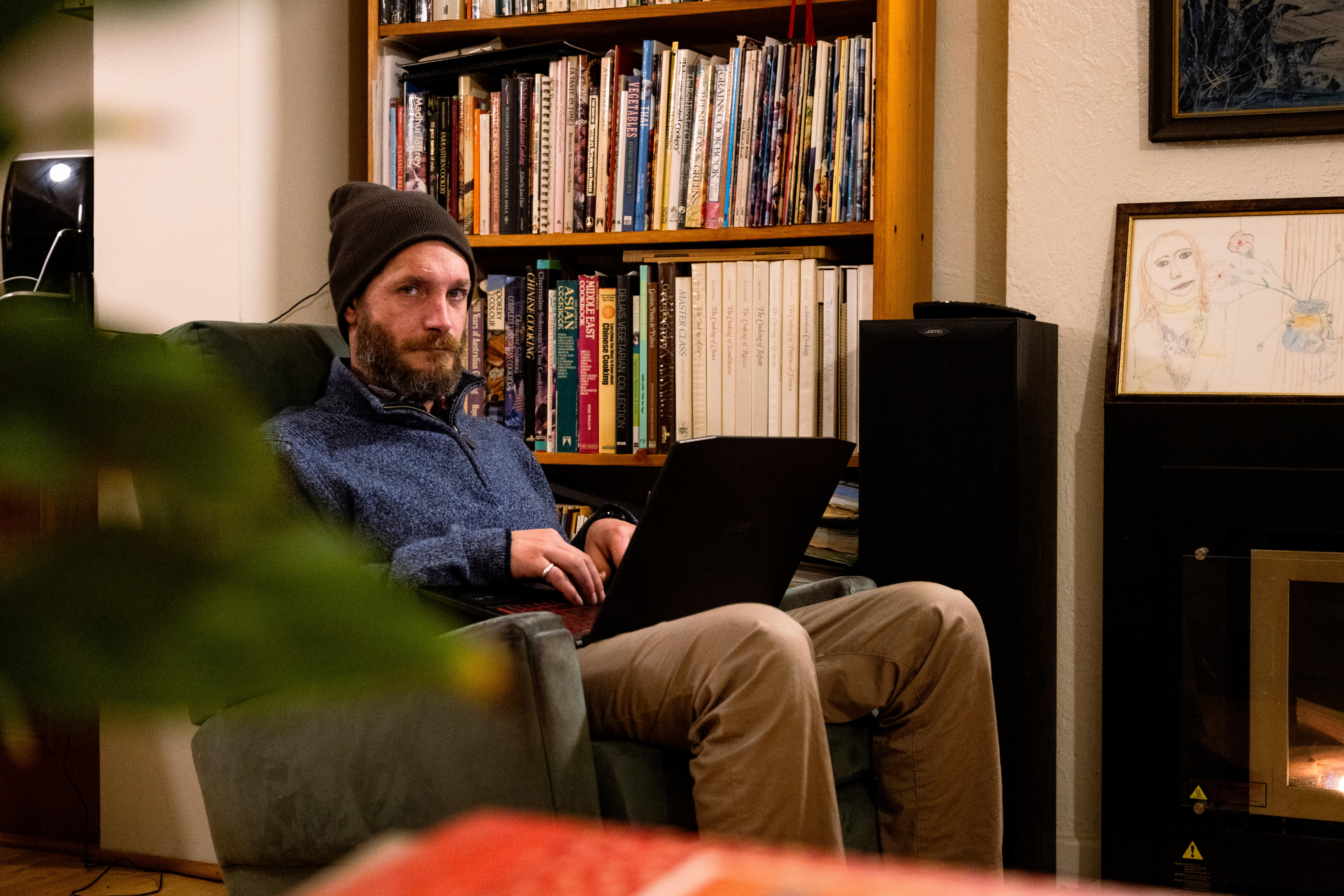 Jimmy sits in his living room on his laptop.