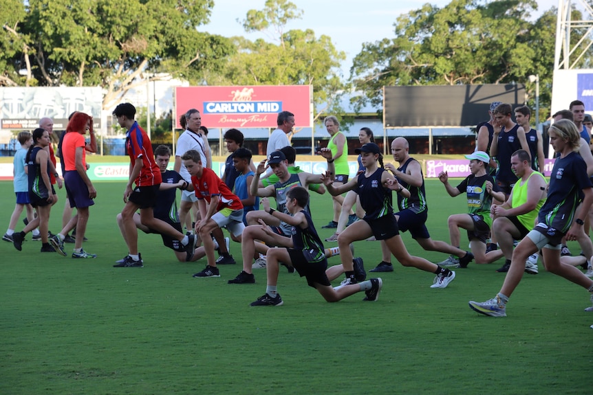 A group of umpires stretch at Nightcliff Oval.