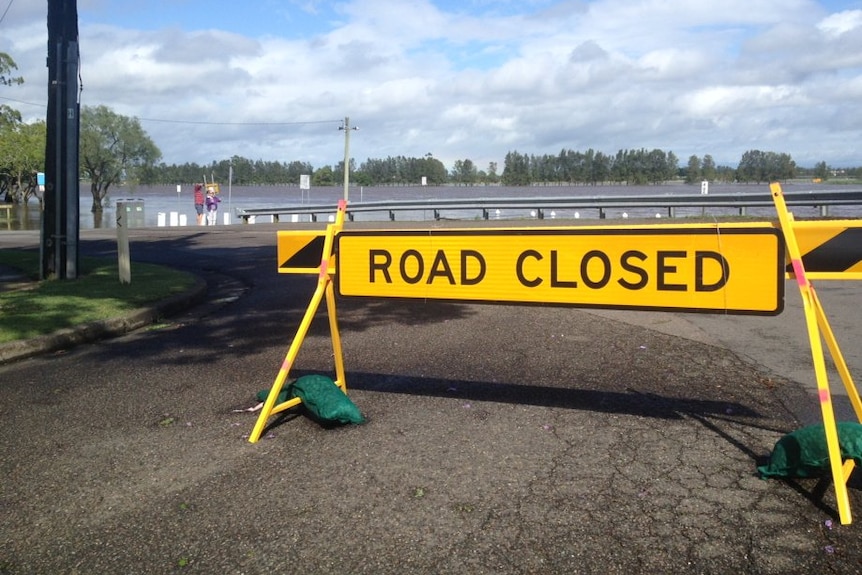 A 'road closed' sign blocks access to a Raymond Terrace street.