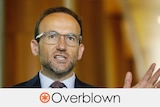 Adam Bandt wears clear-framed glasses and is talking. Verdict: OVERBLOWN with an orange asterisk