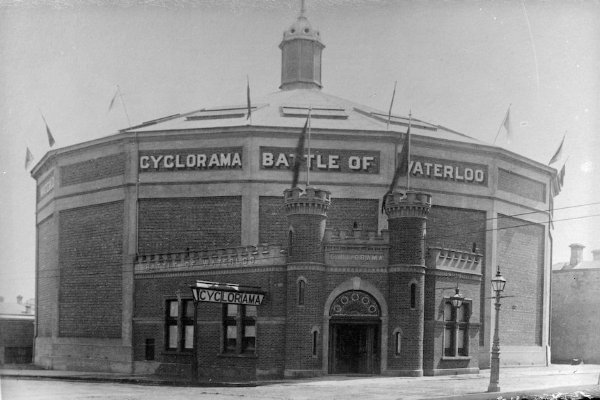 A black and white photo of a large circular building.