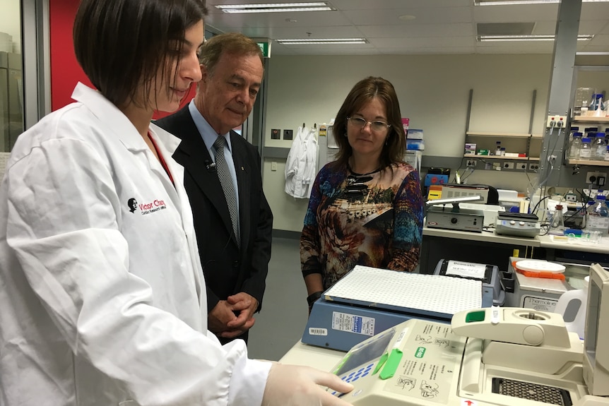 A doctor, a researcher and Pamela McKenzie in a laboratory.