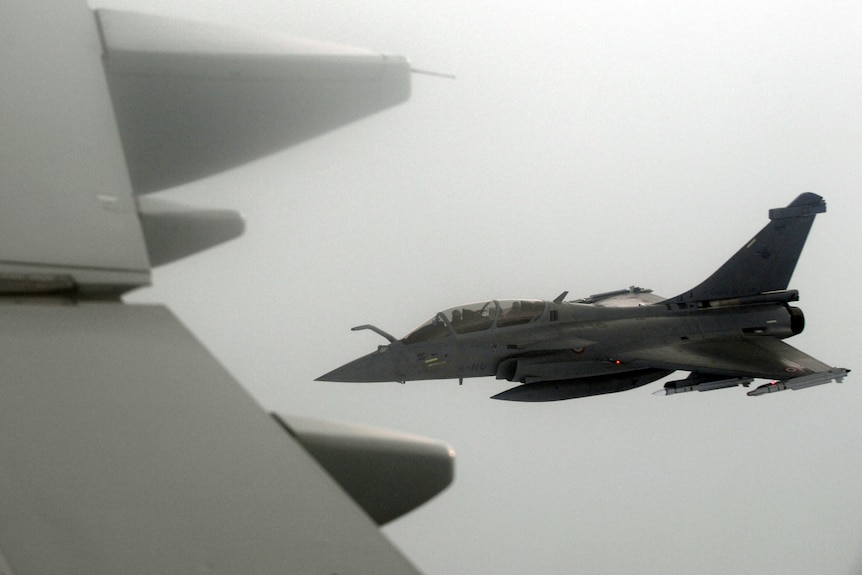 A French Rafale fighter jet flies through thick clouds