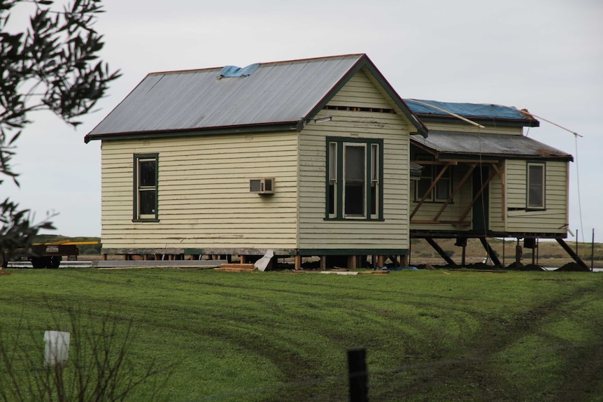 An old, recently moved building sits on a residential block.