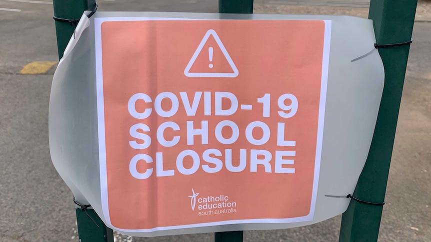 A sign on a fence at a school