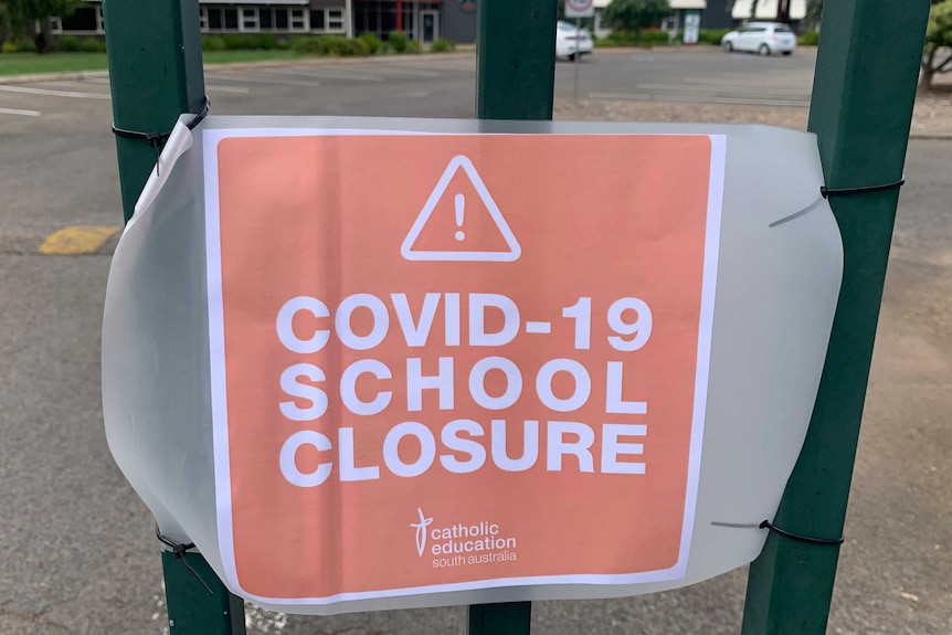 A sign on a fence at a school