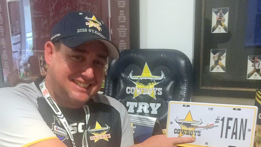 Troy Wilkinson poses with his Cowboy's memorabilia