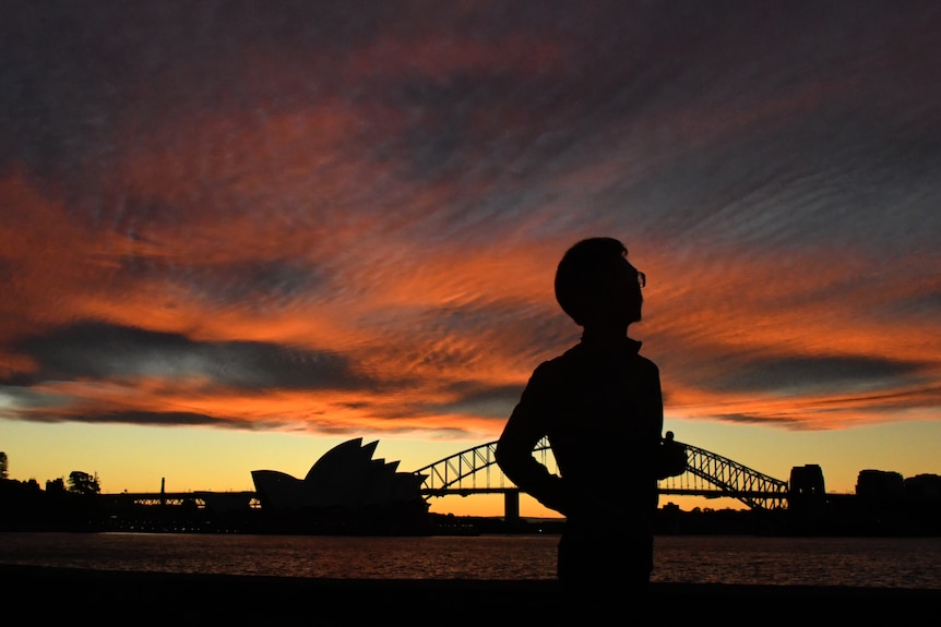 悉尼夕阳中慢跑的人。