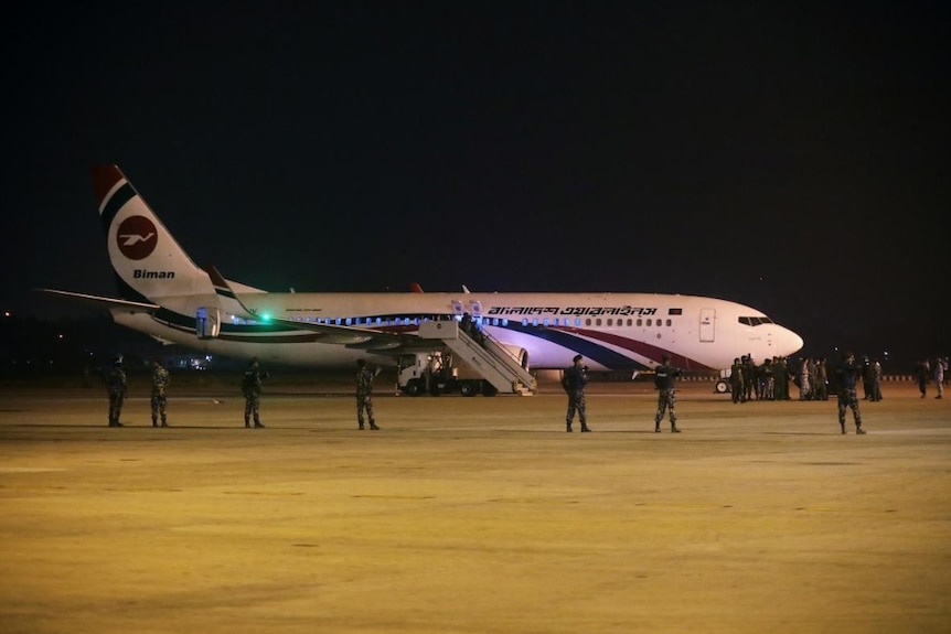 Military commandos stand guard by a Bangladesh plane.