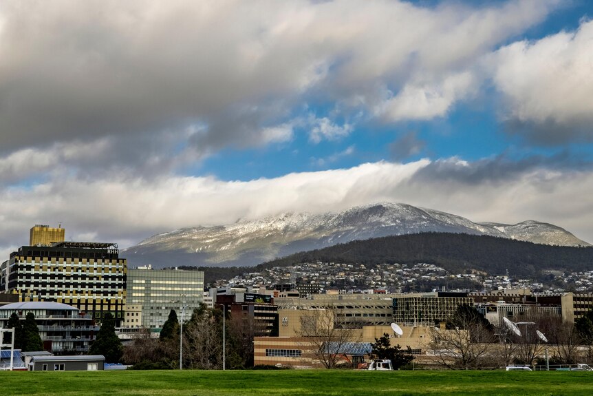 Hobart's kunanyi/Mount Wellington looms behind the city on a snowy day