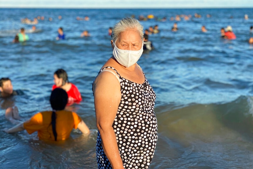 A woman wearing a face mask stands on a beach in Vung Tau city, Vietnam.