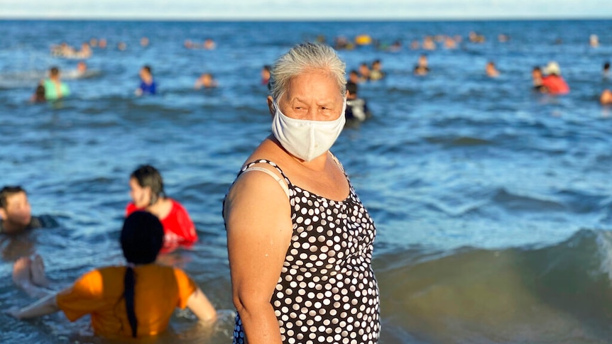 A woman wearing a face mask stands on a beach in Vung Tau city, Vietnam.