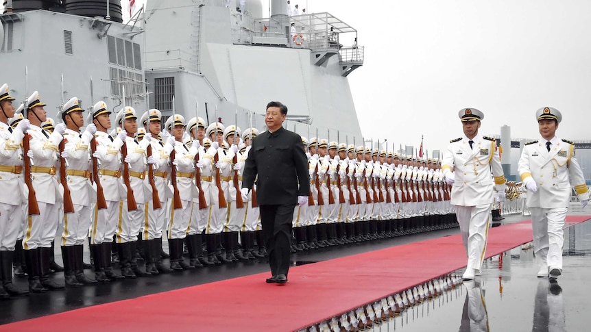 Chinese President Xi Jinping walks past a row of Chinese sailors holding bayonets