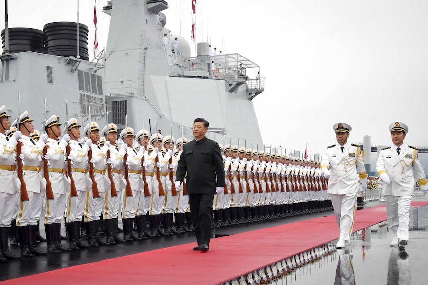 Chinese President Xi Jinping walks past a row of Chinese sailors holding bayonets