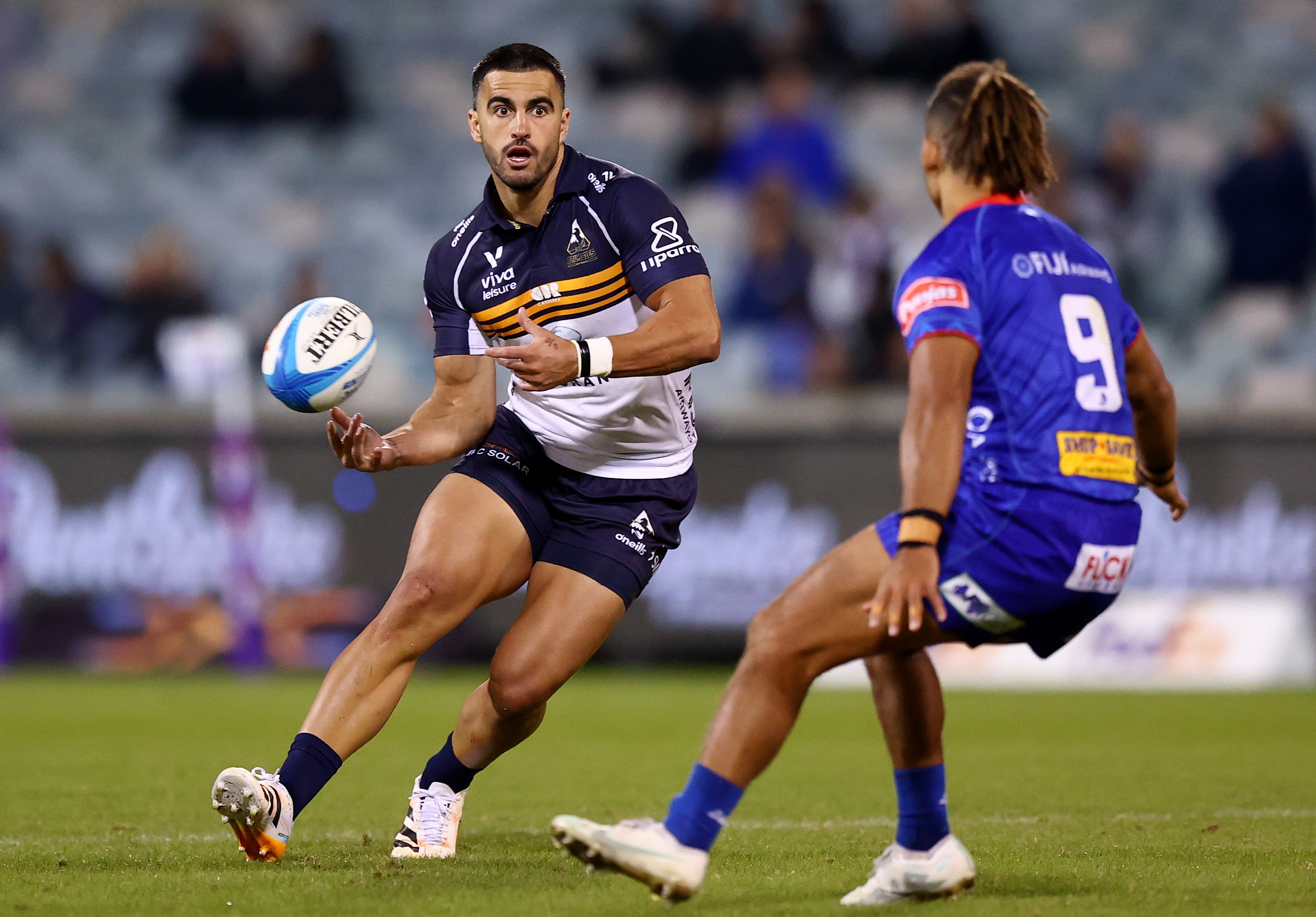 Tom Wright passa a bola para os Brumbies contra os Drua.