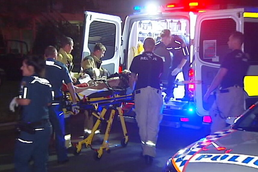 An injured man on a stretcher being put in an ambulance on the Gold Coast