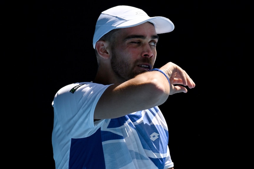 A French male tennis player wipes his face at the Australian Open.