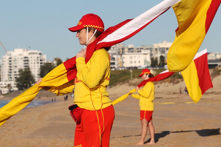 Surf lifesavers with flags at a beach.
