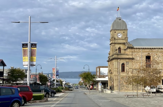 Toma gran angular con coches aparcados y un edificio.