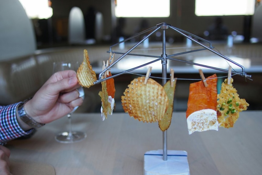 Various types of potato crisp served hanging on a miniature clothesline.