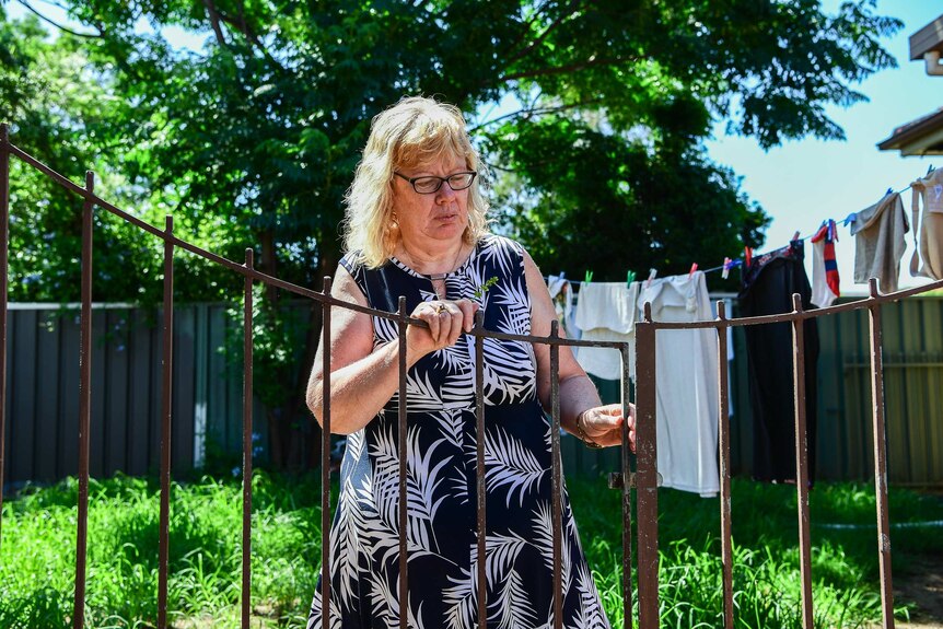 Vicki Walker in her garden closing a gate