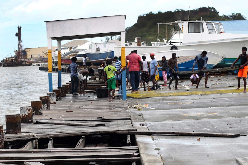 People recover broken parts of the dock.