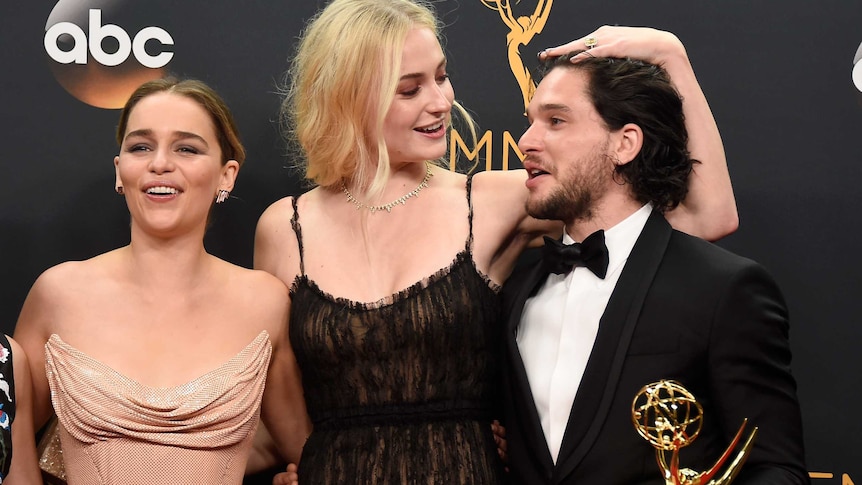 Emilia Clarke, Sophie Turner and Kit Harington pose for the press after their win