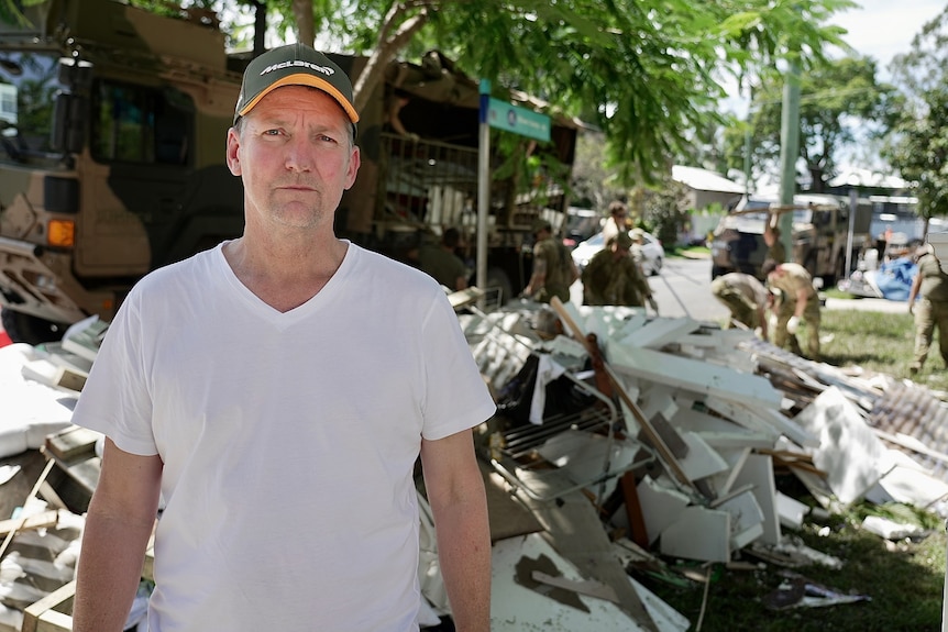 Matthew Eggins-Allman stands outside his Chelmer home with rubbish behind him was inundated.