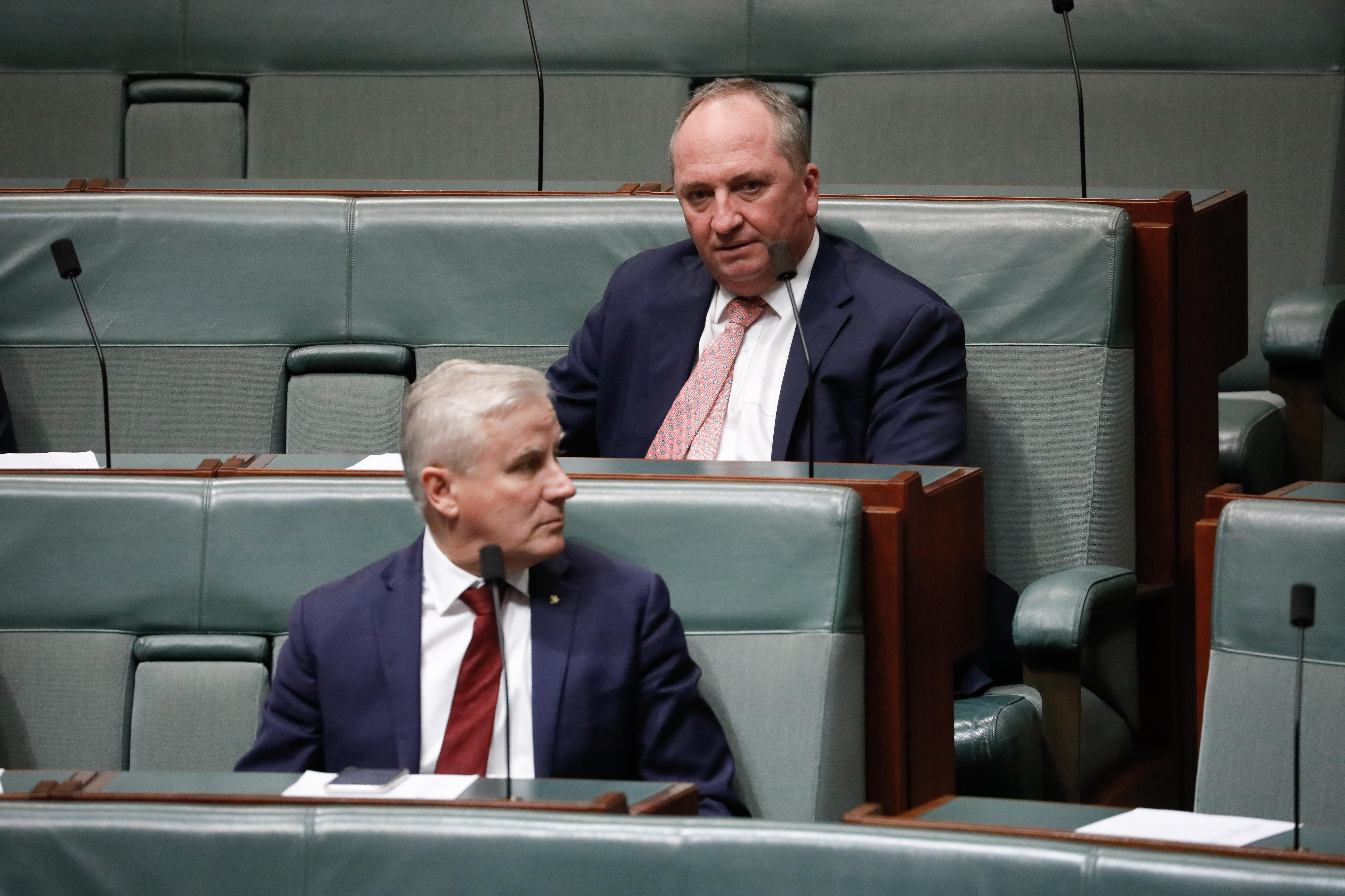 McCormack olha por cima do ombro esquerdo. Joyce está sentada no banco traseiro.