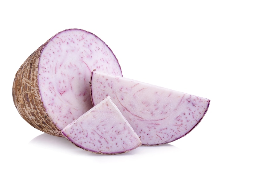 Slices of cut taro vegetable on white background