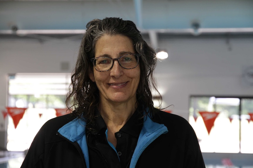 Swimming instructor Nina Nyitrai in front of a swimming pool.