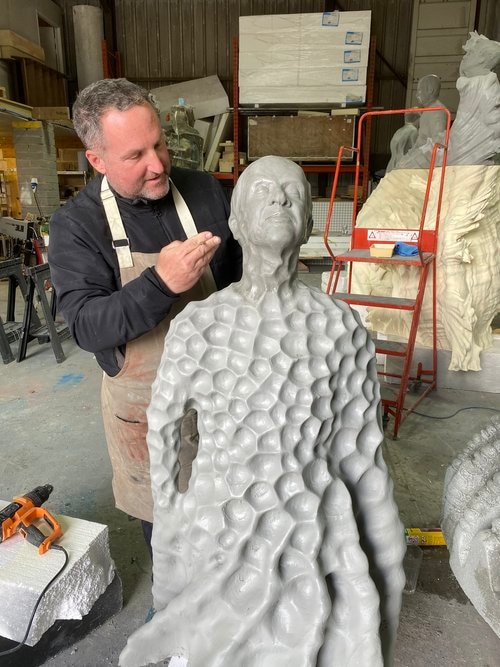 A man examines a concrete sculpture 