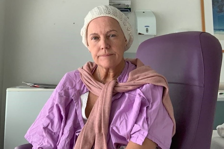 Woman in purple hospital gown.