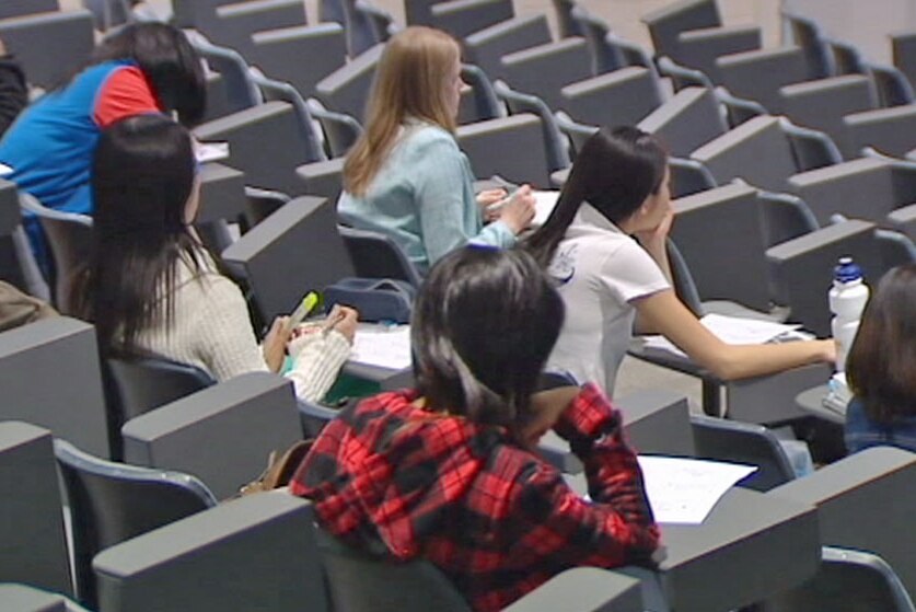 Video still: University students sitting in a lecture theatre