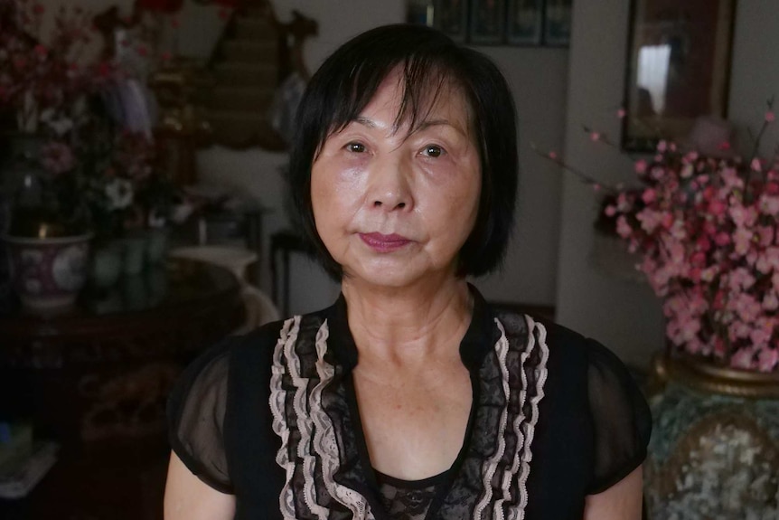 A woman frowns in a portrait in her home.