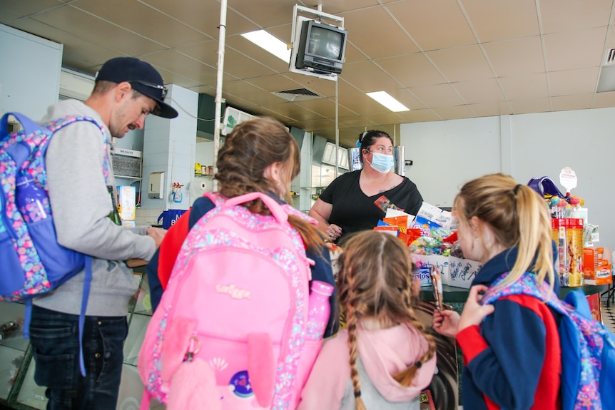 Unidentified school children crowd a counter at a milk bar